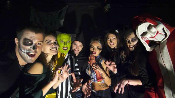 Halloween party, night, twilight, in the rays of light, young people frighten the spectators, everyone is dressed in scary costumes for Halloween. High quality photo - Foto, Imagen