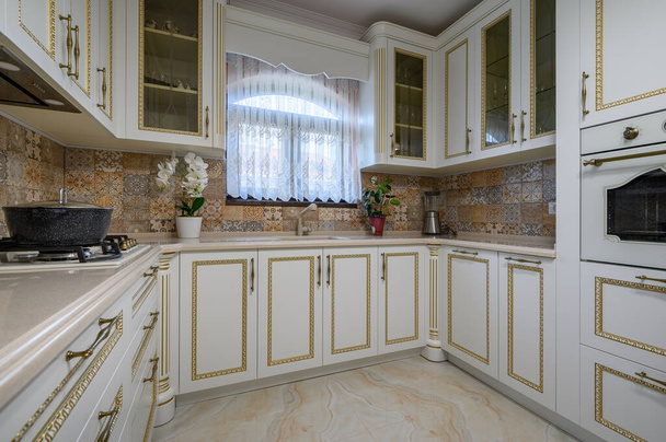 Λευκή κλασική ζεστή κουζίνα και τραπεζαρία στο εσωτερικό του σπιτιού της πόλης - Φωτογραφία, εικόνα