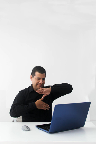 Latino adult man speaks Mexican sign language with a deaf person through a laptop in a video call - 写真・画像