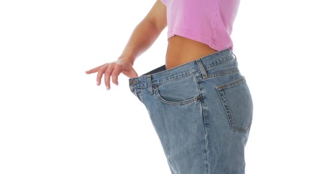 Žena předvádí hubnutí v pytlovité džíny - Záběry, video