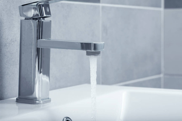 Stream of water flowing from tap in bathroom - Fotoğraf, Görsel