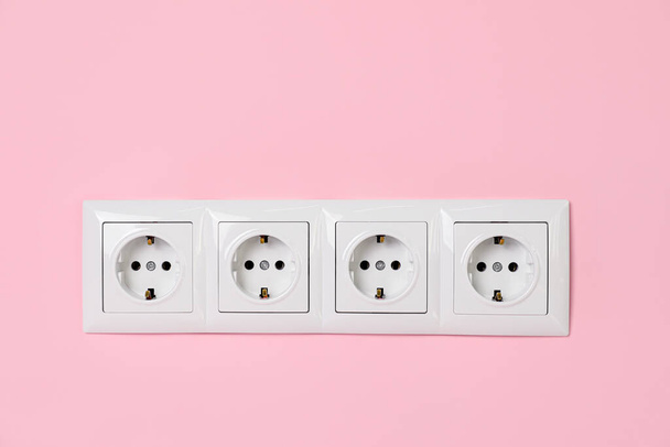 Power sockets on pink wall. Electrical supply - Fotoğraf, Görsel