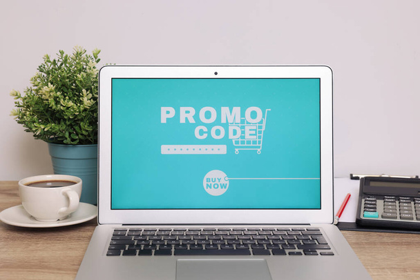 Laptop with activated promo code on wooden table indoors - Foto, immagini