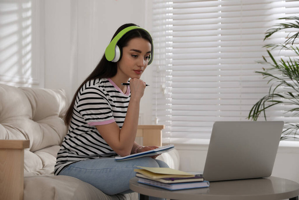 Mujer joven viendo webinar en el sofá en casa - Foto, Imagen
