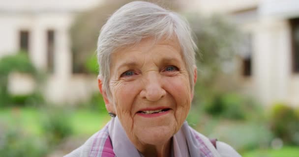 Portrait of happy senior woman with laugh, smile and happiness during retirement and free time standing outside in garden, park or backyard. Face elderly lady feeling confident, positive and content. - Filmati, video