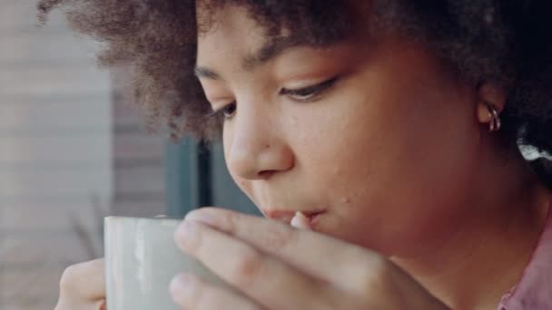 黒人女性がコーヒー、紅茶、幸せな平和、マインドセットを飲み、自宅の窓でリラックスすることを考える。笑顔の若いアフリカ人の顔午前中に熱い飲み物のマグカップをすすります,反射とインスピレーションのアイデア. - 映像、動画