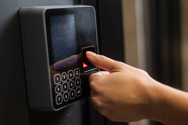 A woman opens the door with her fingerprint. Modern keyless entry lock - Foto, afbeelding