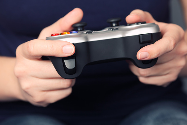 Young woman plays video game using a gamepad - Foto, Imagem