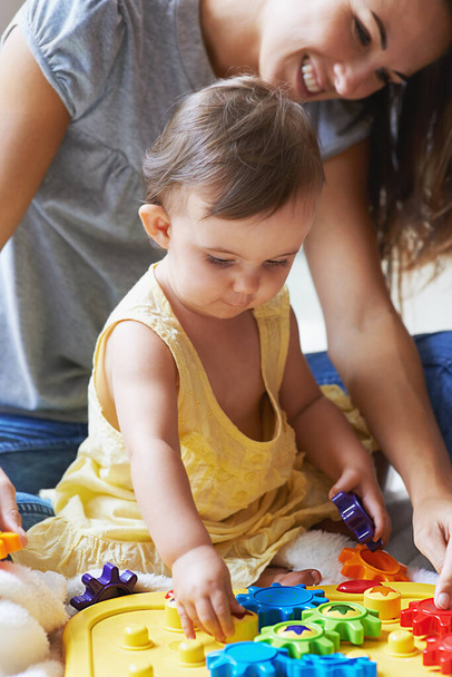 Shes such a clever little girl. an adorable baby girl sitting on the floor with her mom and playing with toys - Φωτογραφία, εικόνα
