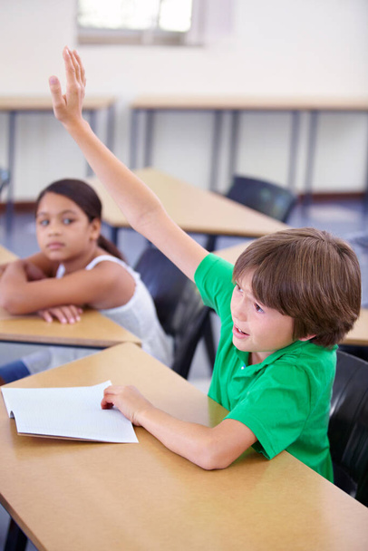 Ich weiß. Ein kleiner Junge hält seine Hand im Unterricht hoch, um eine Frage zu beantworten - Foto, Bild