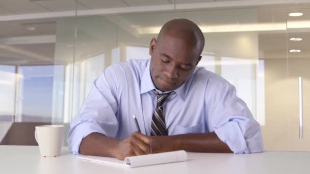Afro-Amerikaanse zakenman werkt aan bureau gooien van papier - Video