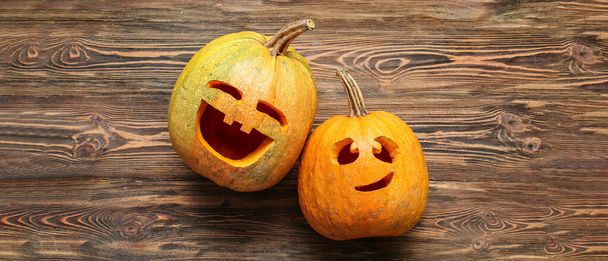 Carved Halloween pumpkins on wooden background, top view - Фото, зображення