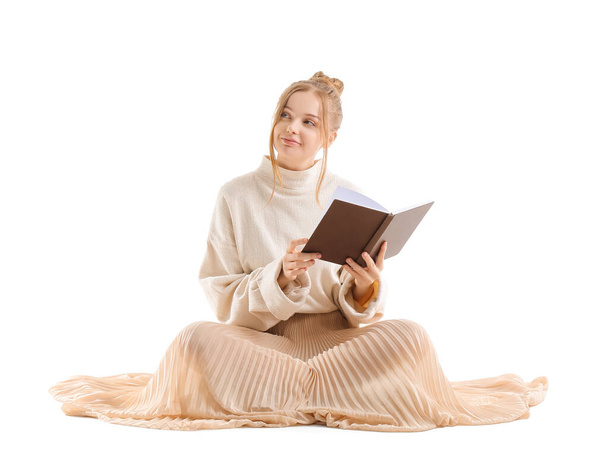 Mujer joven bonita con libro sentado sobre fondo blanco - Foto, Imagen