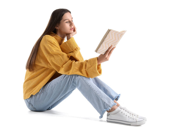 Beautiful woman in yellow sweater reading book on white background - Zdjęcie, obraz