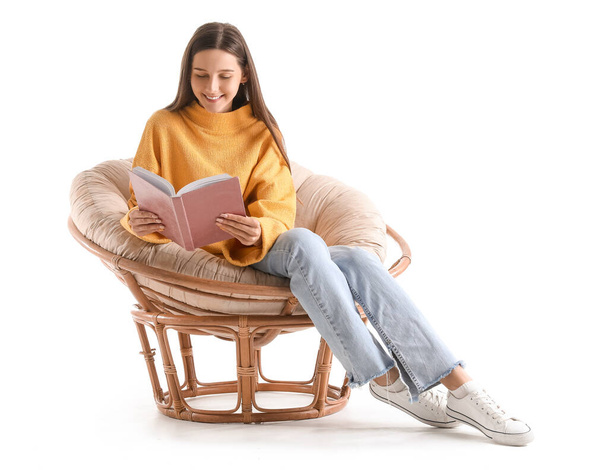 Beautiful woman reading book in armchair on white background - Фото, изображение