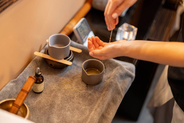 Masérka nanáší olej na ruce před masáží, zblízka - Fotografie, Obrázek