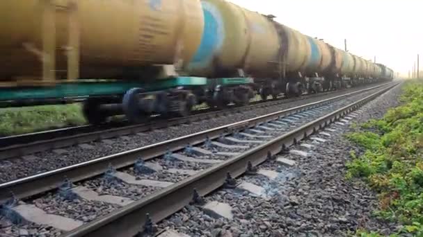 Vonatozás síneken. Az áruszállító vonat tehervagonjai a vasúti sínek mentén haladnak.. - Felvétel, videó