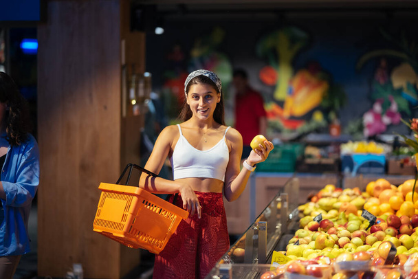Frauen gehen im Supermarkt einkaufen. Auswahl der Äpfel im Geschäft - Foto, Bild