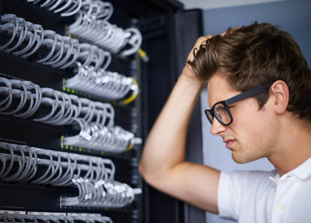 Taking care of your network needs. A computer technician scratching his head - 写真・画像