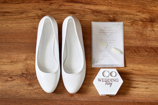 Βέρες, προσκλήσεις και παπούτσια της νύφης σε ξύλινο φόντο. Προετοιμασία για το γάμο. Γιορτή γάμου. - Φωτογραφία, εικόνα