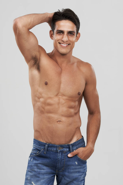 In control of his physique. A handsome young man smiling at the camera - Foto, Imagen