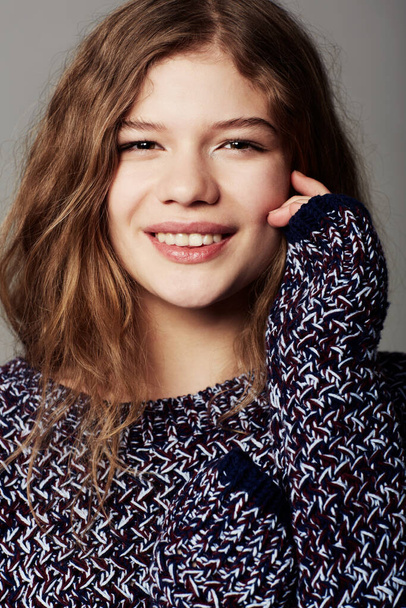 Απλή ευτυχία. Πορτρέτο μιας ελκυστικής νεαρής έφηβης που φοράει φανέλα σε γκρι φόντο - Φωτογραφία, εικόνα