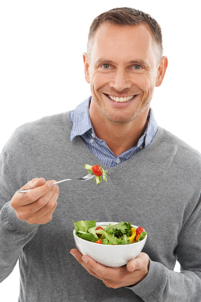 Manter-se saudável através da dieta. Estúdio retrato de um homem maduro desfrutando de uma tigela de salada isolada em branco - Foto, Imagem