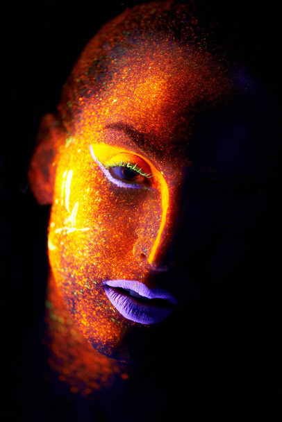 Neonová krásko. Portrét mladé ženy s neonovou barvou na tváři pózující - Fotografie, Obrázek