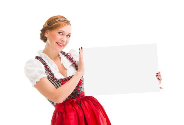 Bavarian woman in dirndl, holding blank signboard. - Fotoğraf, Görsel