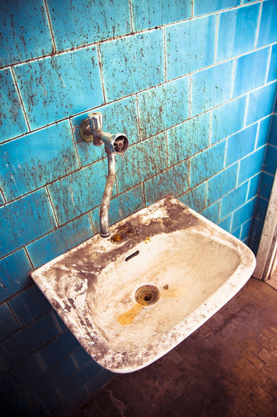 Old sink in a public abandoned restroom - toned image - Photo, Image