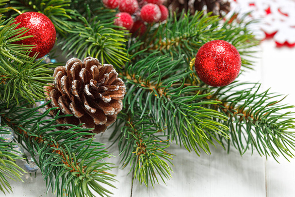 Composición navideña, rama de árbol de Navidad con juguetes, conos sobre fondo de madera - Foto, Imagen