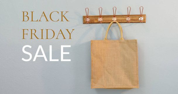 Composition of black friday sale text over brown shopping bag in background. Black friday, retail, american tradition and celebration concept digitally generated image. - Фото, зображення