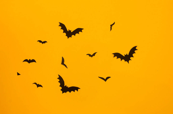 yellow background with black paper bats. Halloween decoration concept - Foto, imagen