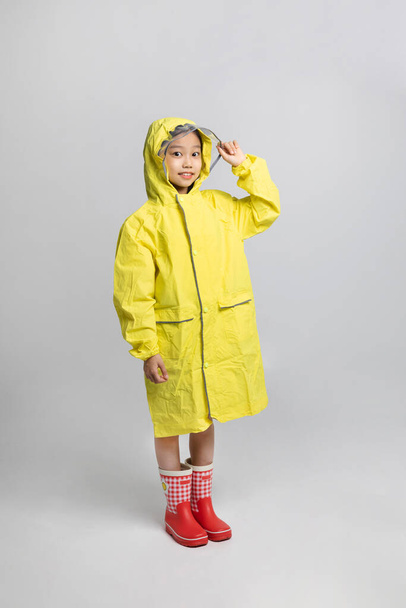 cute young Korean girl, rainy season concept in white background studio, wearing raincoat - 写真・画像