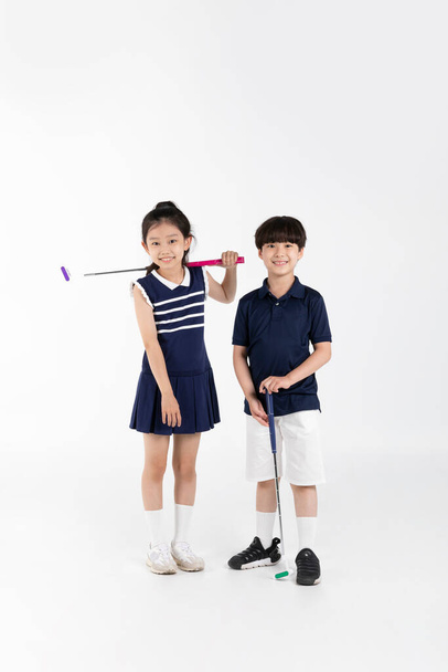 Korean boy and girl_fitness and exercise concept in white background__swinging golf club - Photo, Image