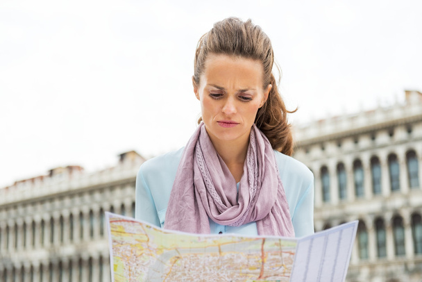 Fiatal nő keresi a térképen, a piazza san marco, Velence, Olaszország - Fotó, kép