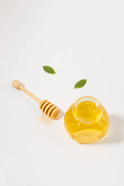 bottled honey and honey dipper stick - Фото, изображение