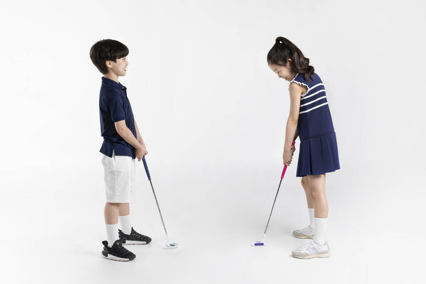 Korean boy and girl_fitness and exercise concept in white background__looking at one's golfing friend - Foto, imagen