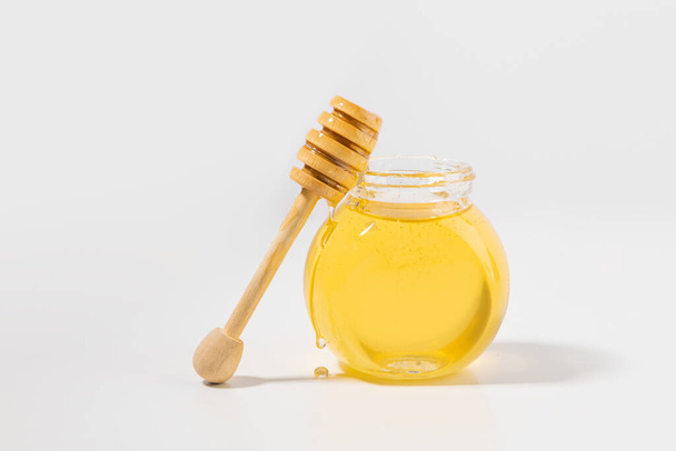 bottled honey and honey dipper stick - Фото, изображение