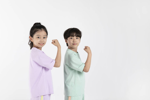 Korean boy and girl_fitness and exercise concept in white background__showing off muscles and strength - Zdjęcie, obraz