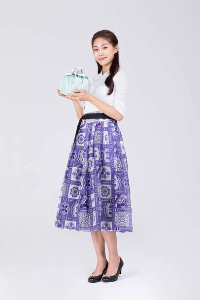 beautiful Korean woman in 20s wearing modern Hanbok_holding gift box - Foto, Bild