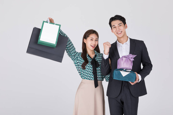 Korean young couple, man and woman wearing modern Hanbok, holding paper bags and gift boxes - Foto, immagini