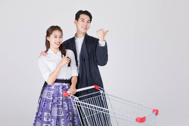 Korean couple, young man and woman in 20s, wearing modern Hanbok, with shopping cart - Zdjęcie, obraz