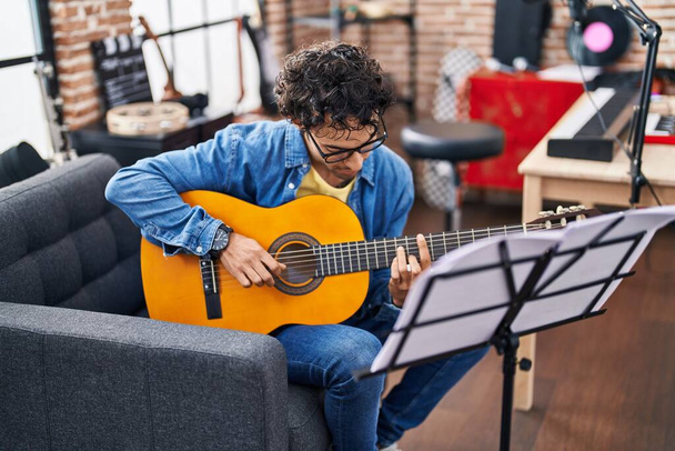 Giovane musicista ispanico che suona la chitarra classica allo studio di musica - Foto, immagini