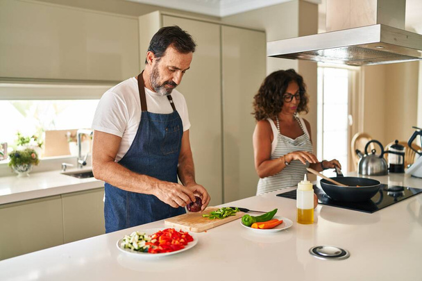 Middle age hispanic couple smiling confident cooking at kitchen - 写真・画像