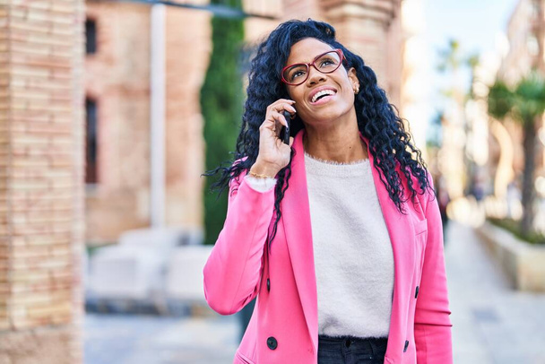 Afrikalı Amerikalı kadın yönetici caddede akıllı telefondan konuşuyor. - Fotoğraf, Görsel