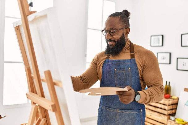 Joven afroamericano artista hombre sonriendo feliz dibujo en el estudio de arte. - Foto, Imagen