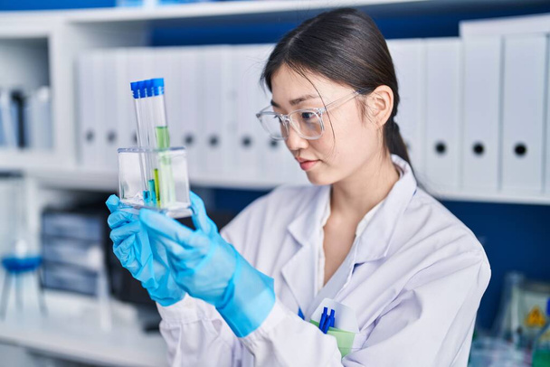 Китаянка-ученый держит пробирки в лаборатории - Фото, изображение