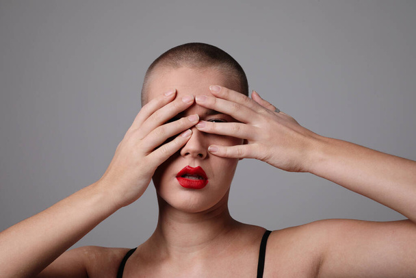 Beautiful young bald woman posing over light grey background. Mock-up. High quality photo. - Valokuva, kuva