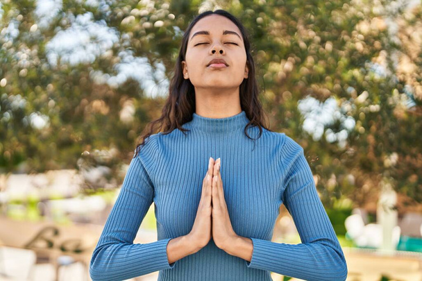 Young african american woman meditating at park - Photo, Image